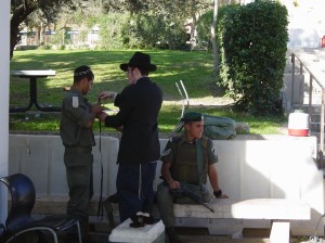 A haredi man wraps Tefillin on a soldier in Hebron in 2005 (Frantzman)