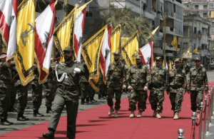 Hezbollah fighters parade before leaving for Syria