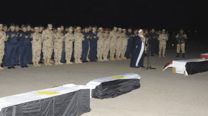 Then general Abdel Fattah al-Sisi prays  with soldiers next to the bodies of Egyptian conscripts murdered in Sinai in January 2014