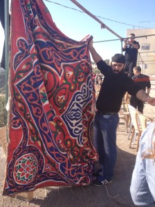 Men hanging a curtain at the mourner's tent (Seth J. Frantzman)