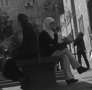 An Arab and Jewish woman sit on a bench in Jerusalem; some people see the city as