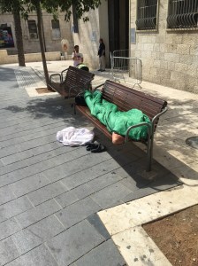 A man sleeps on a bench in Jerusalem (Seth J. Frantzman)